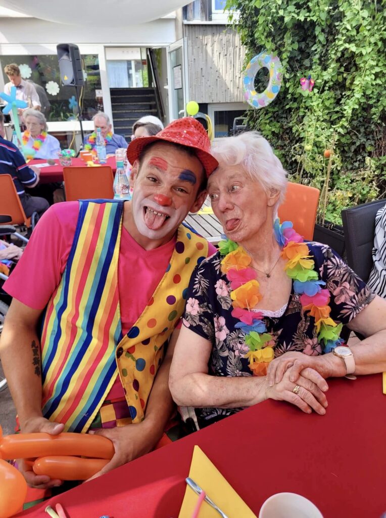 Clown streckt Zunge raus mit Seniorin